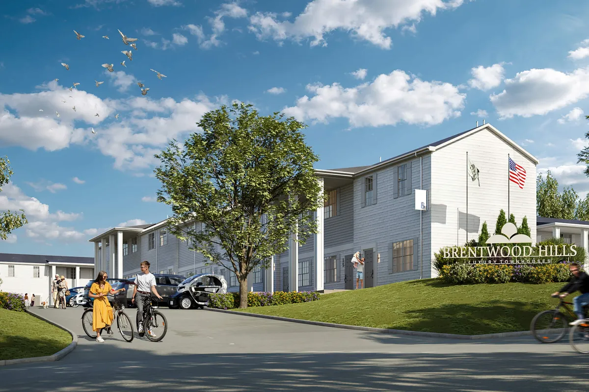 A view of the Brentwood Hills sign with bicyclists in motion, shaded by trees and flanked by parked cars in a relaxed, neighborly driveway scene. The image conveys active community life and easy access to outdoor activities.